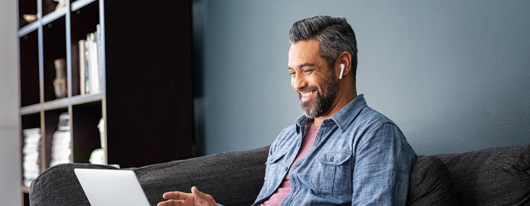 a man sitting on a couch with a laptop